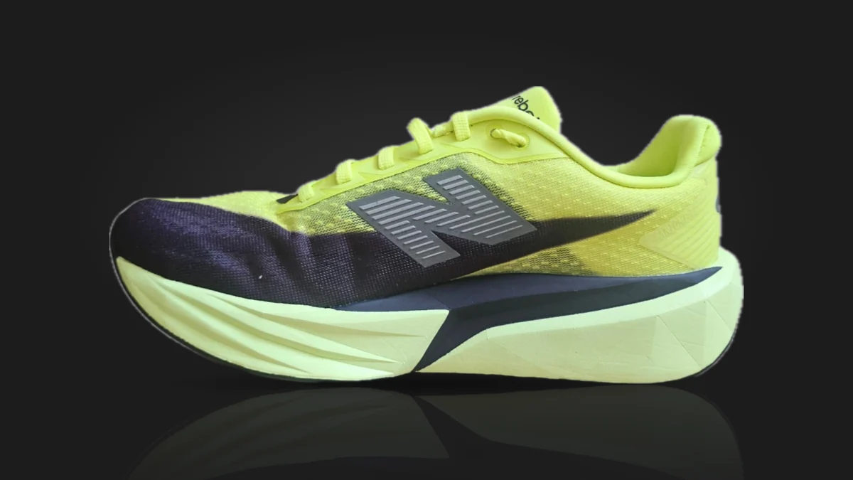 The New Balance FuelCell Rebel v5 from the side: a lime upper fading to navy at the toe, a grey N, and a pale lime midsole