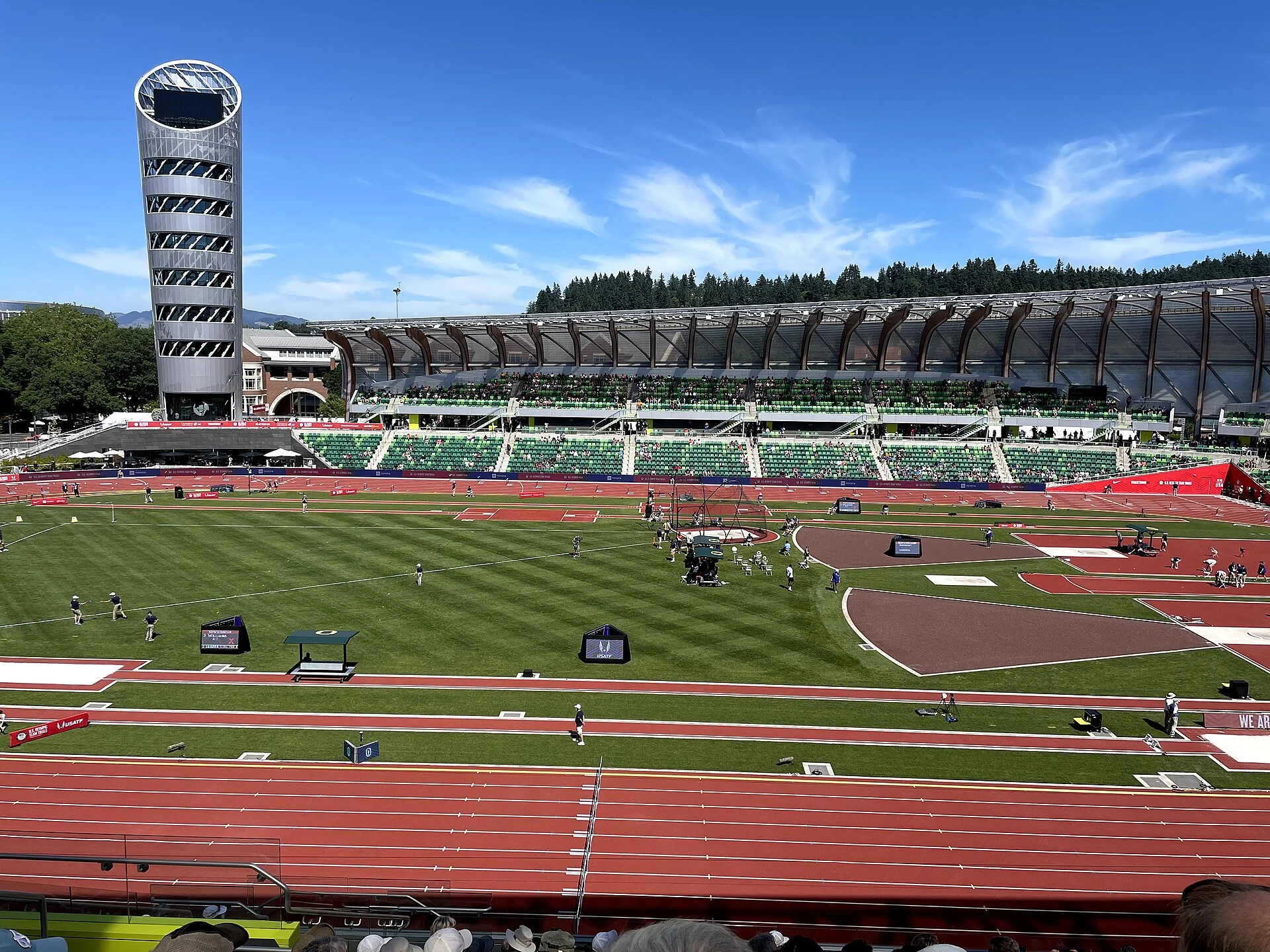 Hayward Field’s tower and long row of timber roof ribs seen across the red athletics track and green infield.